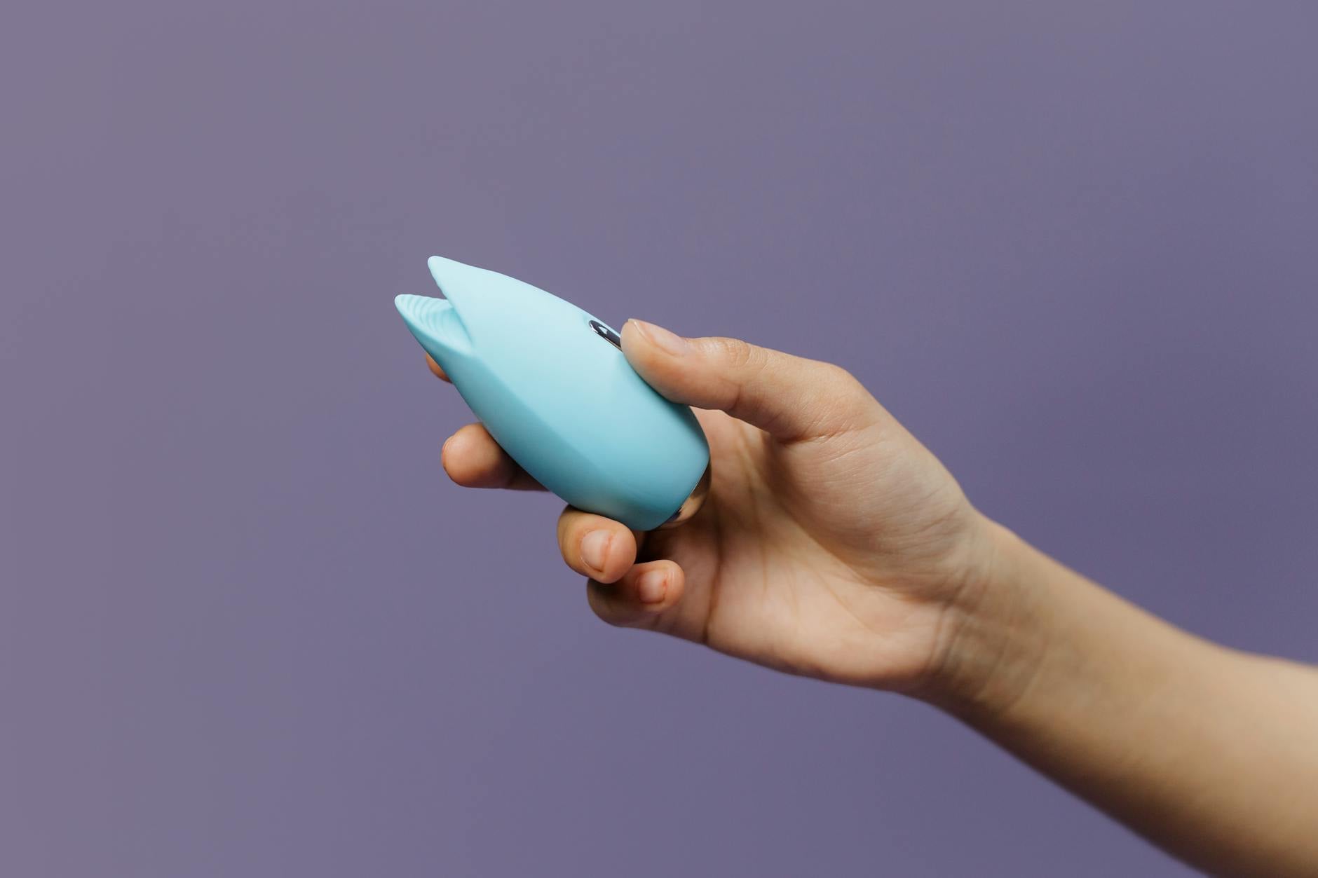 Mano sosteniendo un limón fresco contra fondo amarillo vivido, transmitiendo frescura y vitalidad sexual