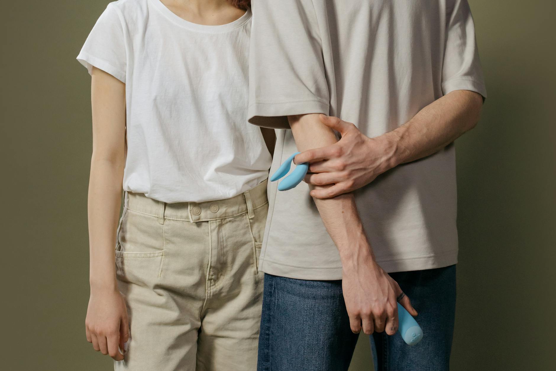 Hand holding a modern vibrator against a purple backdrop, symbolizing solo pleasure and self-care