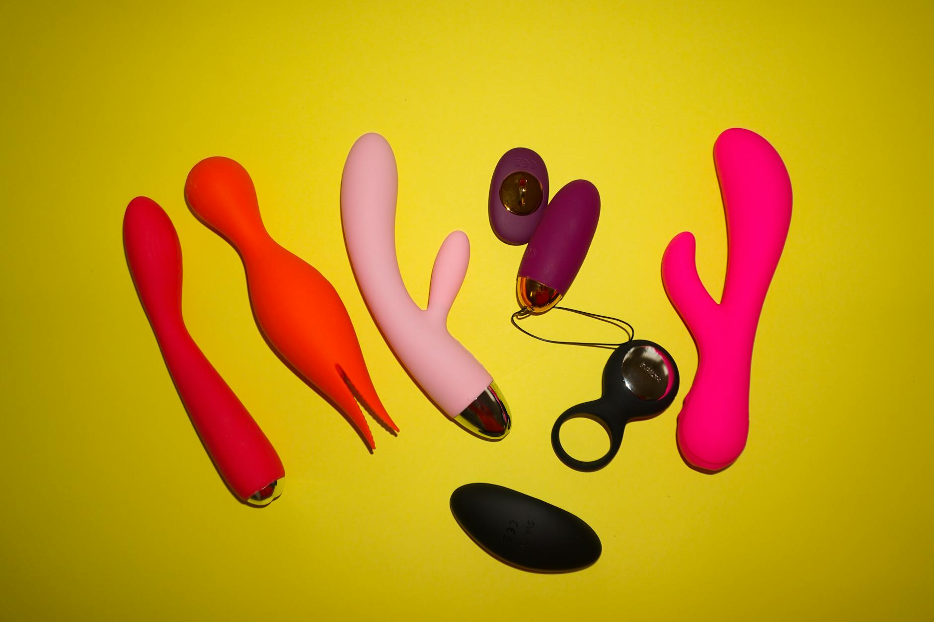 Vibrador de limón y otros juguetes sexuales en tonos vibrantes sobre fondo amarillo