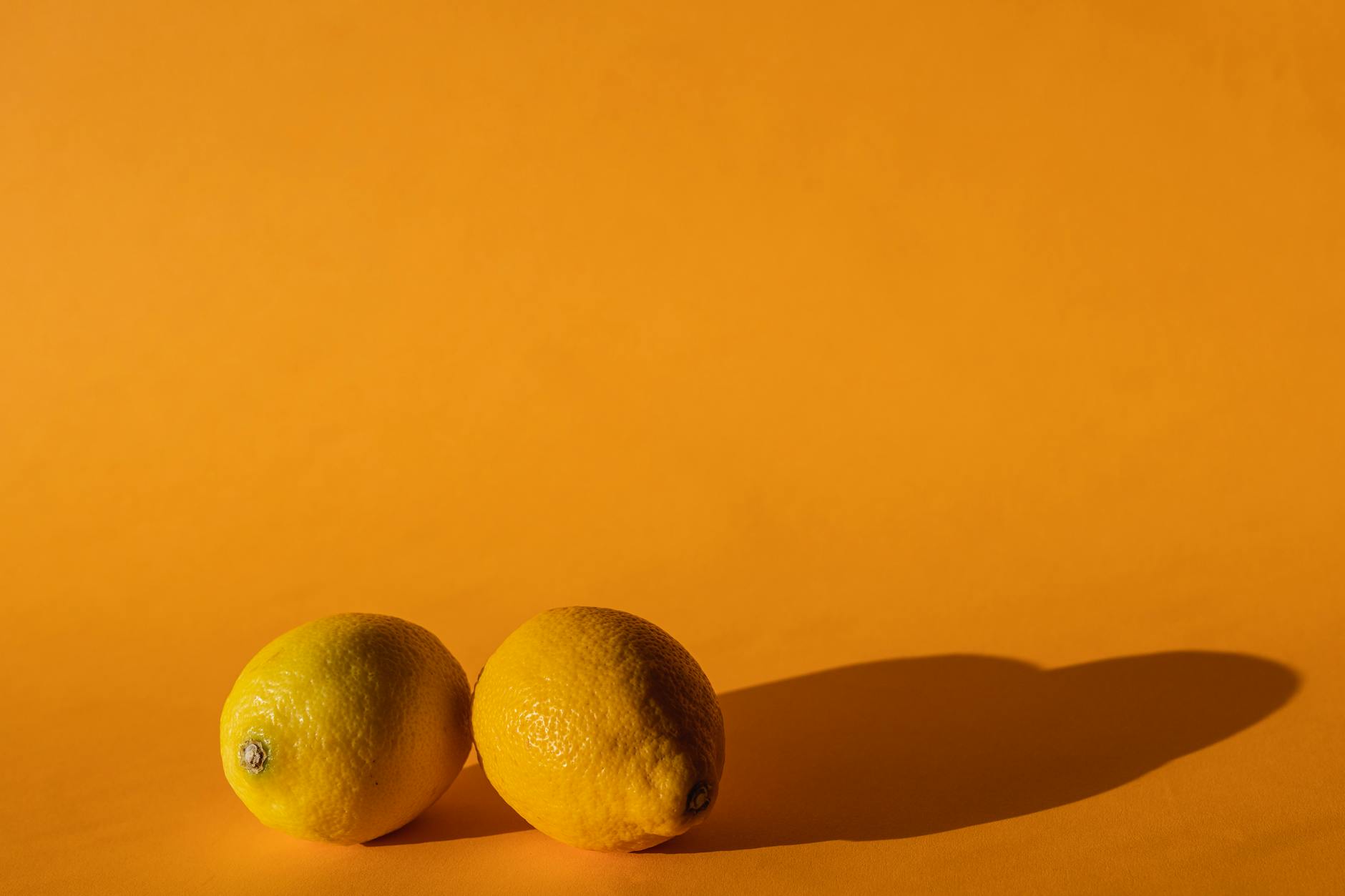 Limones frescos y vibrantes en composición plana sobre fondo amarillo